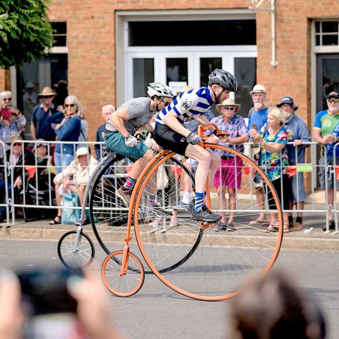 two men racing penny farthing bicycles